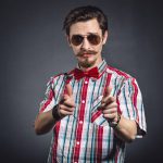 Man in plaid shirt and bow tie with glasses in the studio