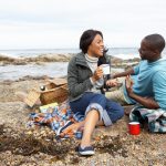 couple-having-picnic-beach-19684078
