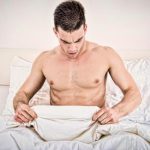naked-man-in-bed-looking-at-himself-under-the-covers